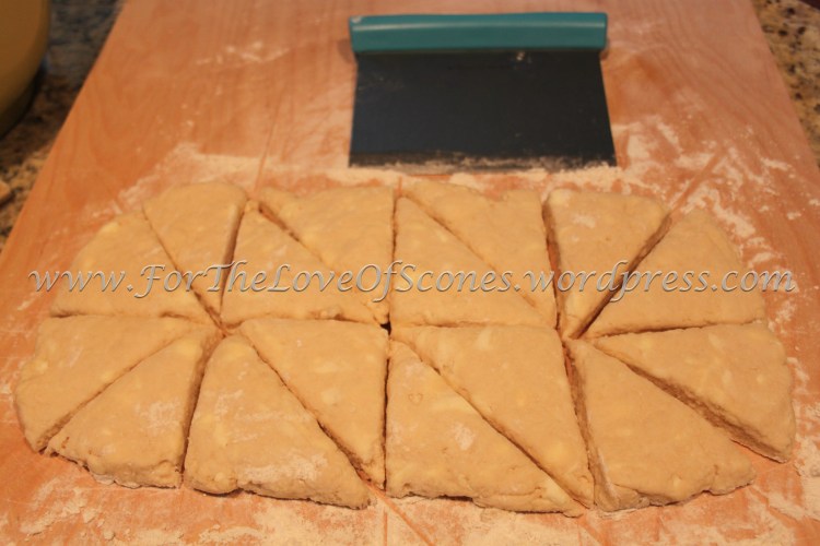 Give the dough a couple of kneads to bring it together, then flatten the dough with your hands into a log about two scone lengths in height and four scone widths in length. Divide into four rectangles, then cut each rectangle into two equal sized squares, then cut each square into two triangles, as shown.